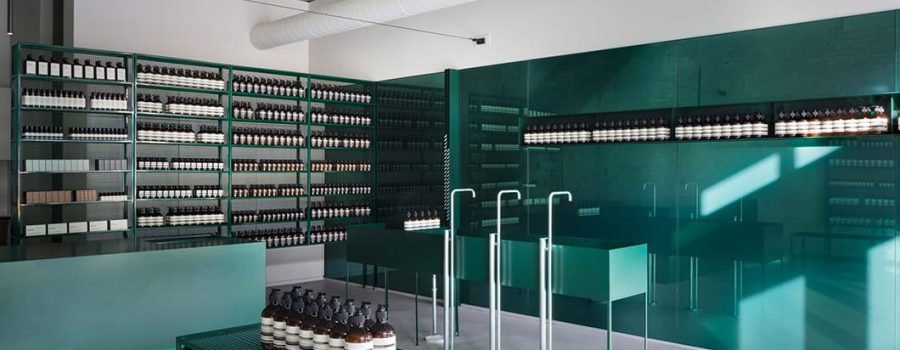 A view of the interior of Aesop West Loop, with Archetype Glass' custom glass wall cladding and shelves