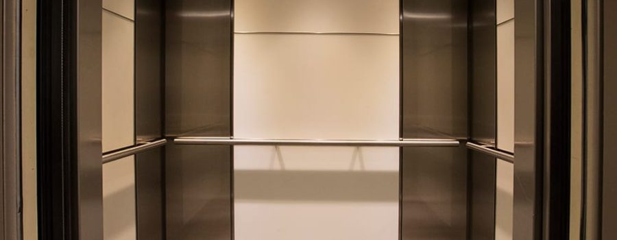 Custom laminated glass elevator cabs in the 6402 Arlington Boulevard elevator