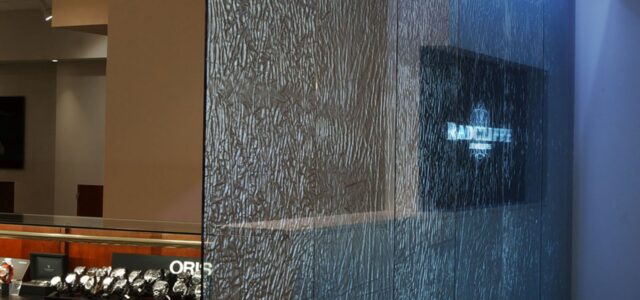 A banner showing the custom fabric laminated glass partition wall created for Radcliffe Jewelers by Archetype Glass