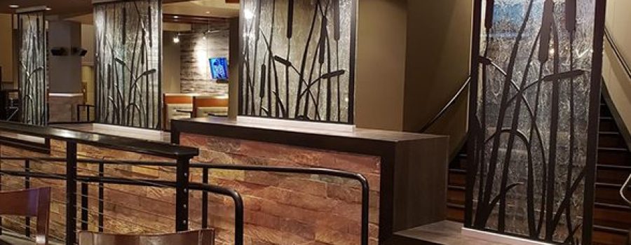 A wide view of the custom textured glass partition walls and custom waterjet cut screens at the Kankakee Grille, by Archetype Glass